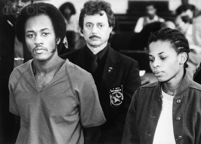 09 Jan 1985, Cincinnati, Ohio, USA --- Original caption: Fugitives Alton Coleman and Debra Brown express little emotion as they are arraigned 1/9 on a series of charges, including two counts of aggravated murder, as an unidentified sheriff's deputy stands guard. Coleman and Brown allegedly went on a six-state crime spree last summer and were captured in the Chicago suburb of Evanston, Illinois. --- Image by © Bettmann/CORBIS